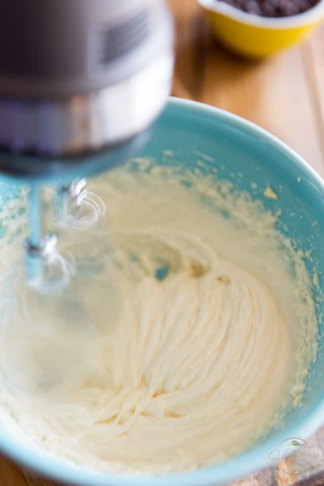 Melted cacao butter, coconut oil, ghee and honey are being creamed with a hand mixer