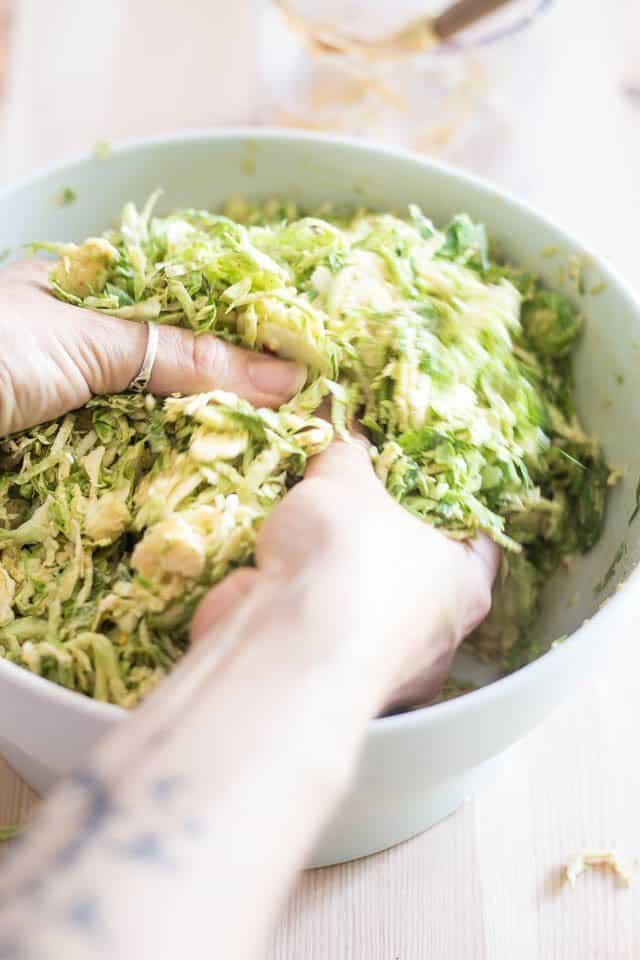 Mixing the Shaved Brussels Sprouts and Dressing | thehealthyfoodie.com