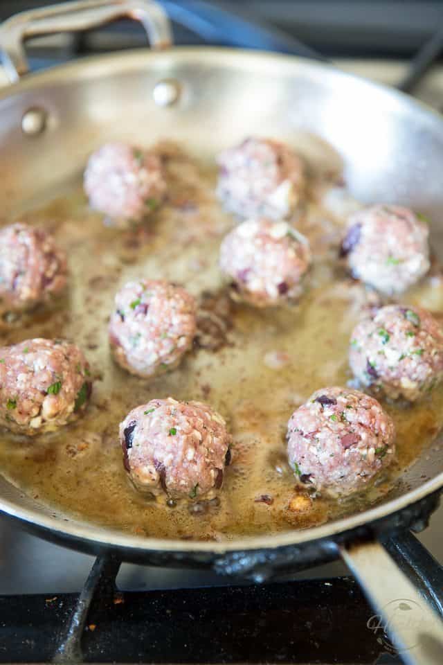 Loaded with tasty pieces of chopped kalamata olives and crumbled feta cheese, these Greek Style Meatballs are so seriously yummy, you won't be able to stop popping them! 