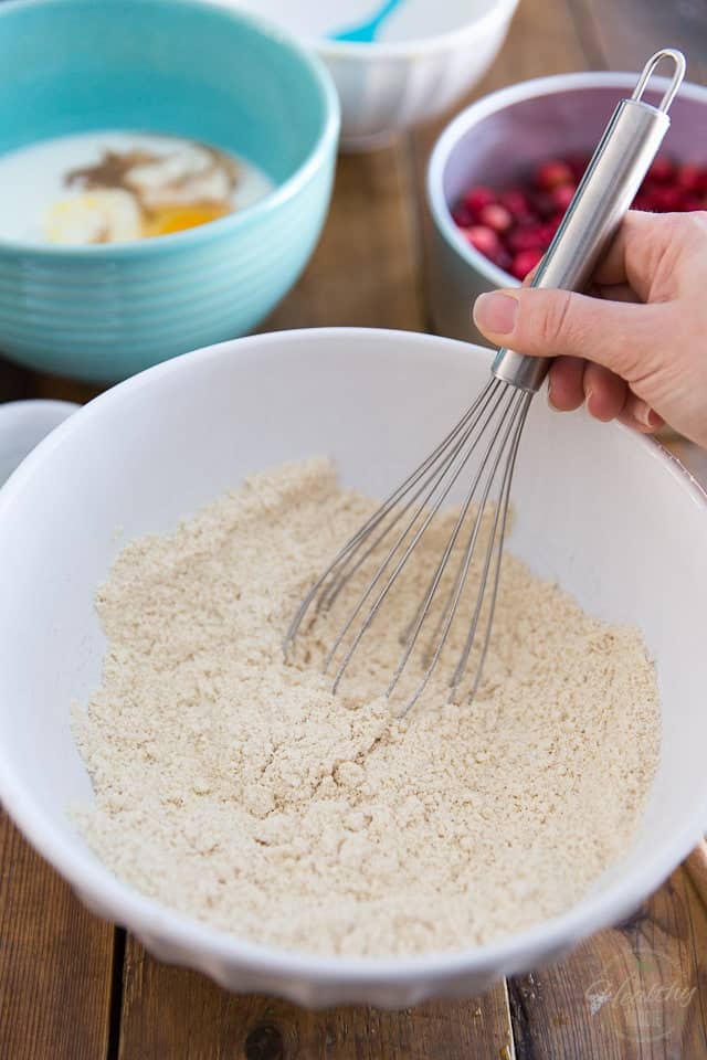A mixture of flours being whisked together in a white bowl