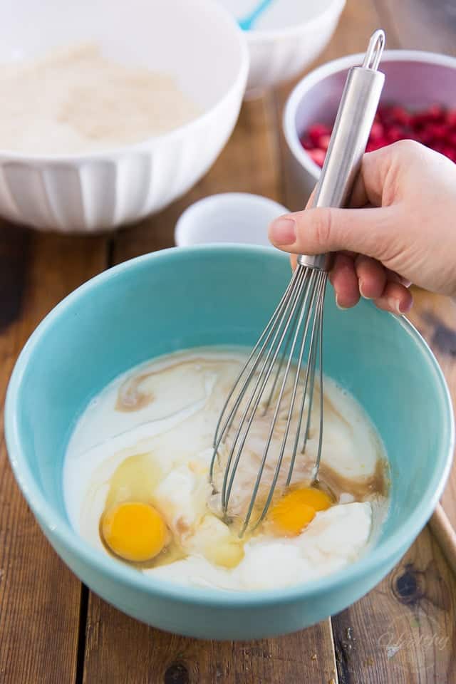 A couple of eggs, yogurt, buttermilk and honey just about to get whisked in a blue bowl