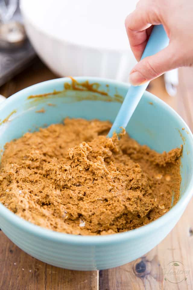 Butternut Squash Muffin batter in a blue bowl getting stirred with blue rubber spatula