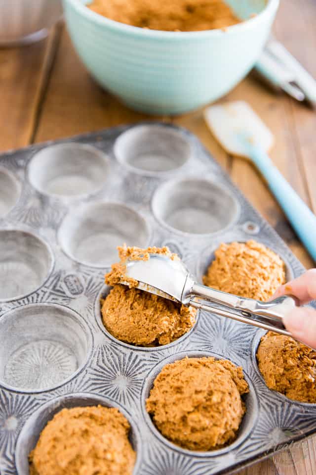 Butternut Squash Muffin batter being divided amongst muffin cups with a spring-loaded ice cream scoop