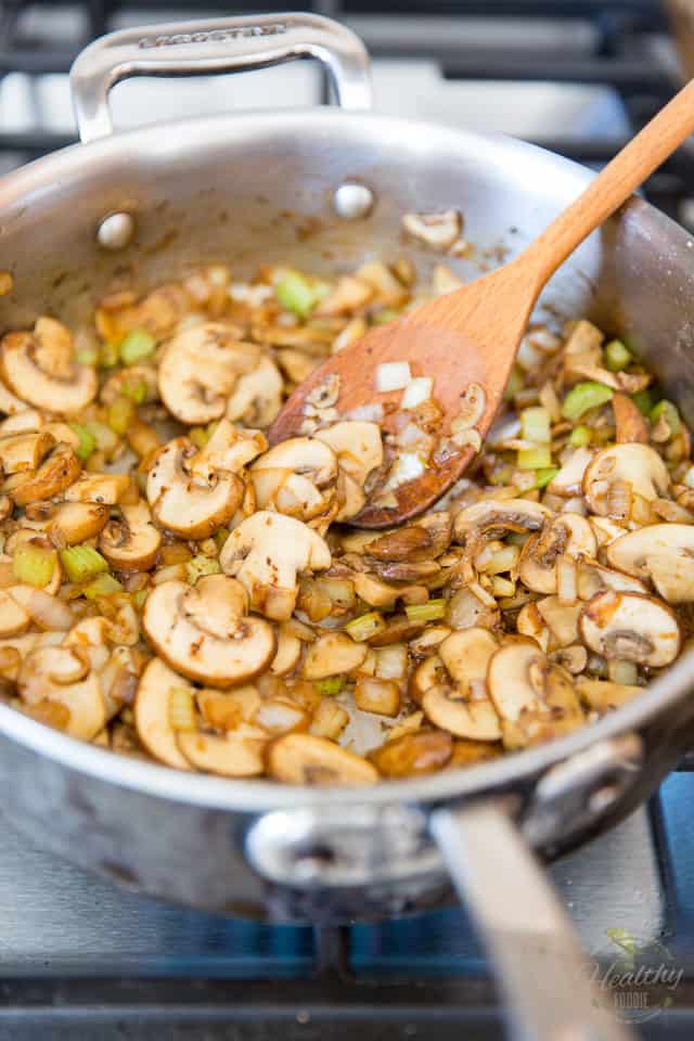 Mushrooms, celery and onions getting sauteed in a stainless steel saute pan