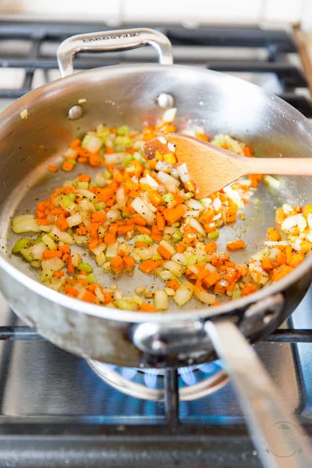 Onions, celery and carrots cooking in a saute pan
