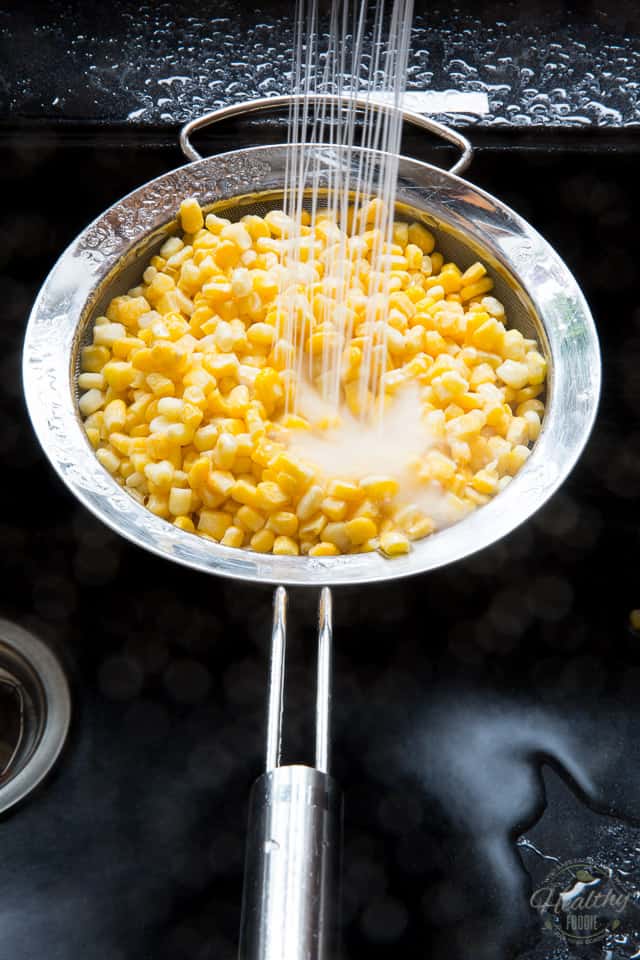 Corn kernels getting rinsed in a fine meshed sieve 