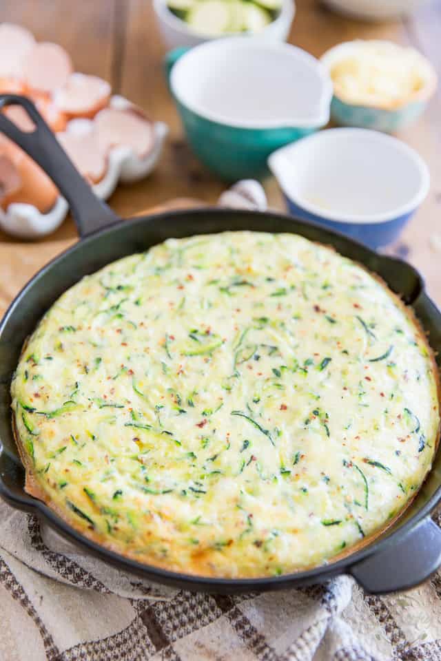 Partially cooked zucchini frittata in cast iron skillet
