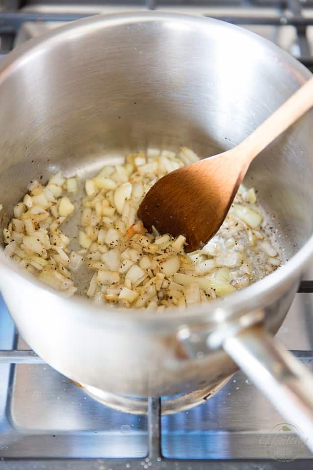 Onions and garlic getting browned in a stainless steel saucepan
