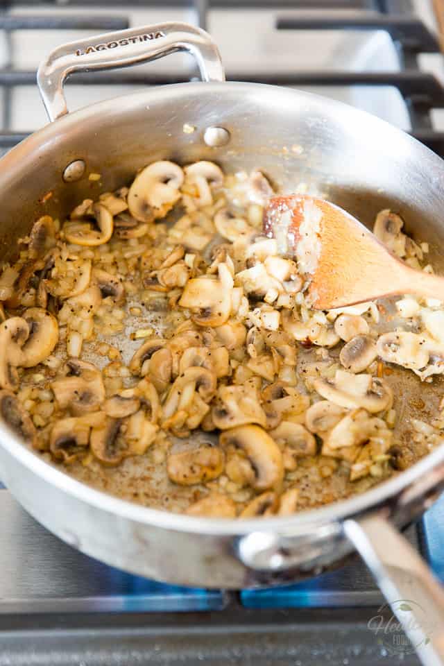 Mushrooms onions and garlic getting browned in a stainless steel saute pan
