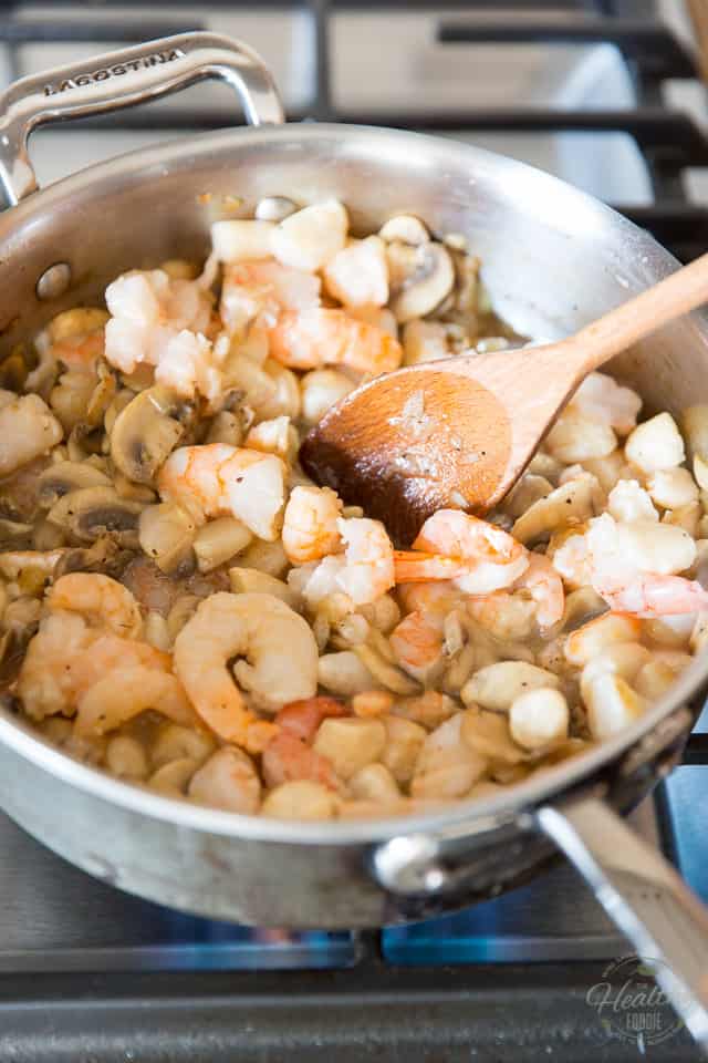Shrimps and scallop cooking in a stainless steel saute pan