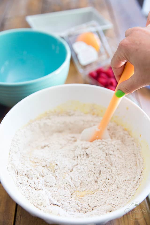 Dry ingredients are getting mixed into wet with a rubber spatula