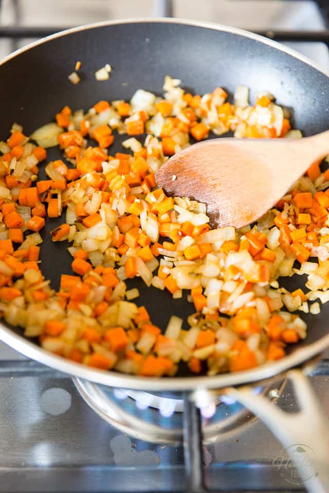 Onions and diced carrots cooking in a non-stick skillet