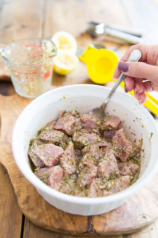 Raw pork cubes getting tossed with marinade