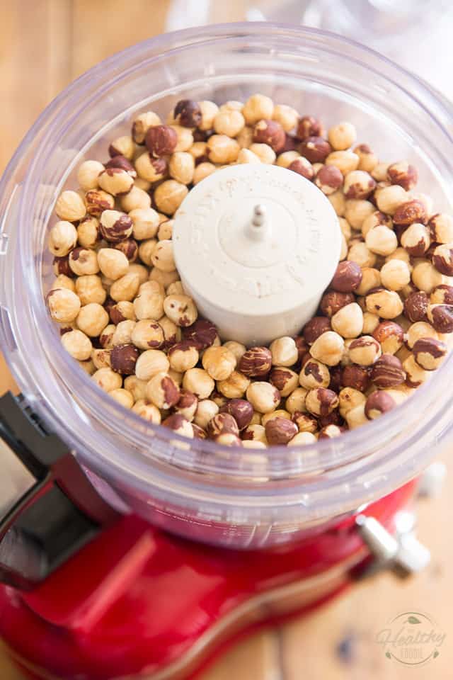 Toasted skinned hazelnuts in the bowl of a food processor