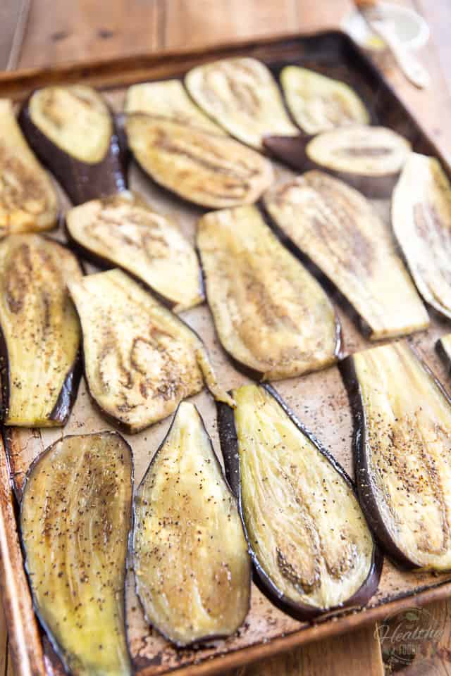 Cooked eggplant slices, on a large baking sheet