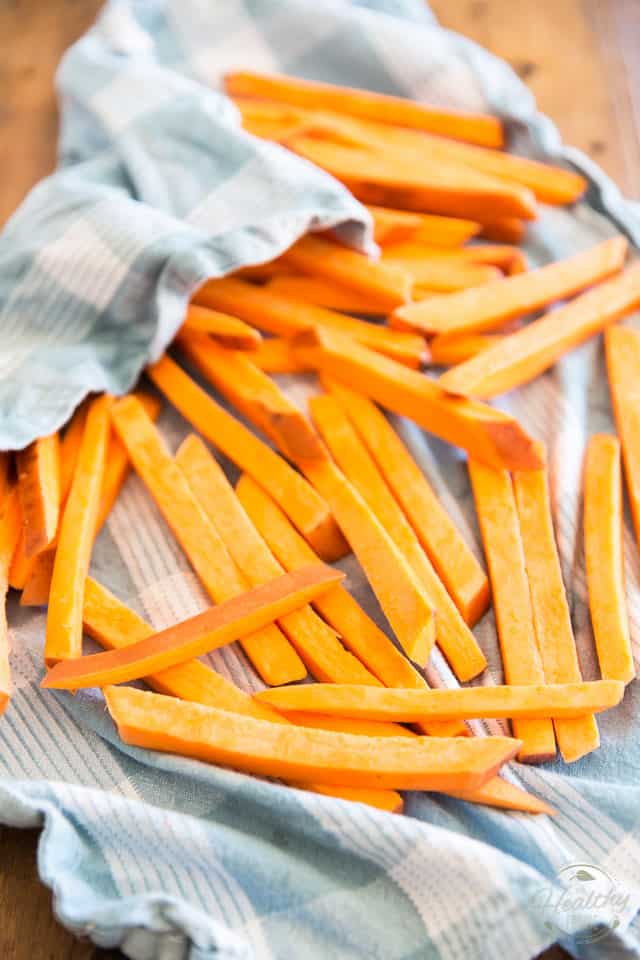 Patting dry the sweet potato strips with a clean tea towel