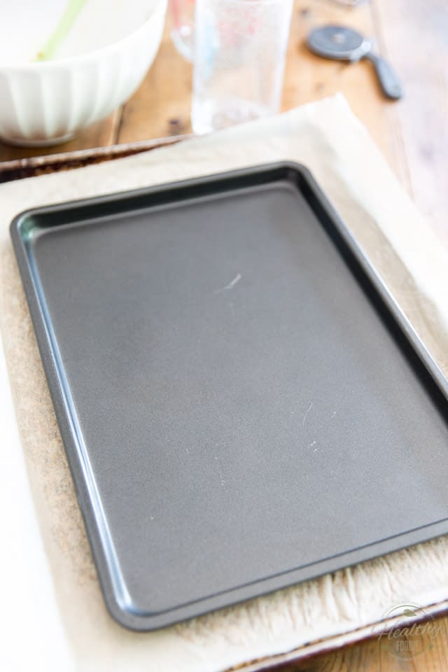 Press the dough down with the help of a smaller baking sheet