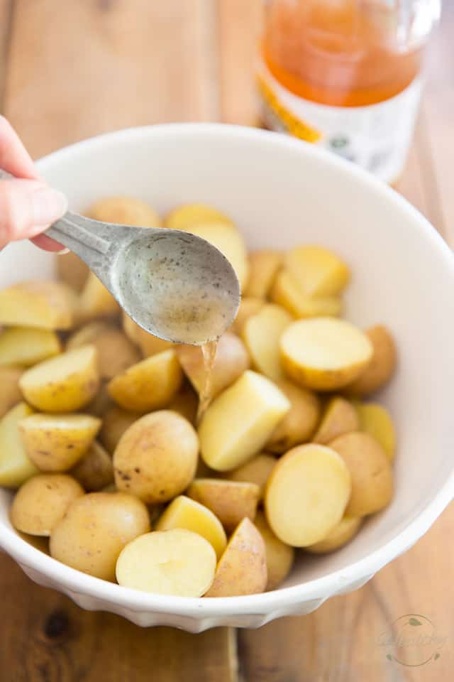 Once the potatoes are cooked, place them in a bowl and add more vinegar