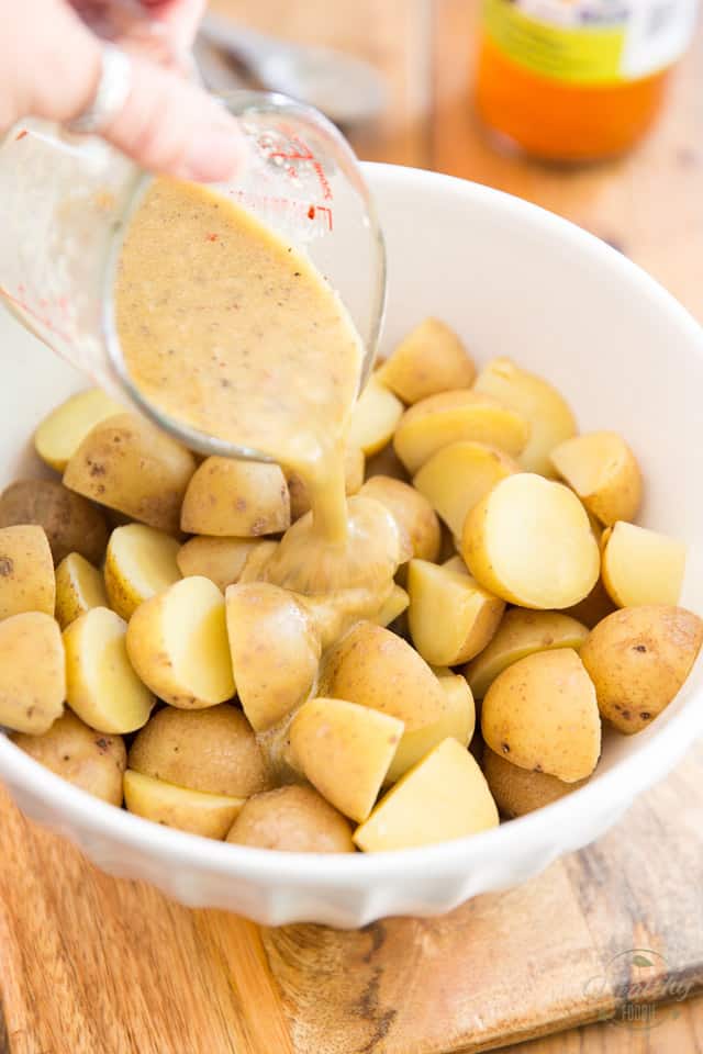 Pour the dressing over the warm potatoes