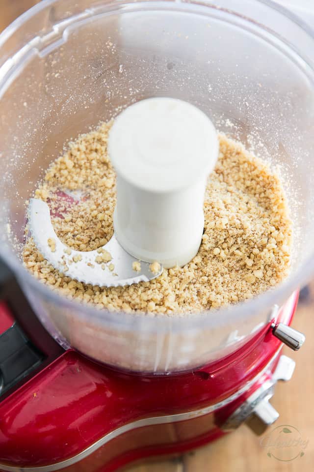 Add walnuts to the bowl of your food processor and reduce to coarse meal