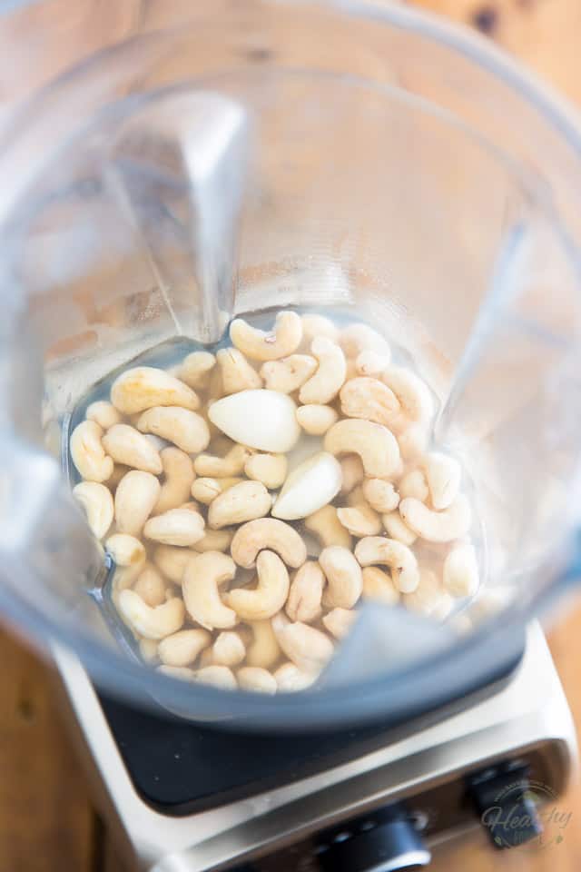 cashews, boiling water and garlic cloves in the container of a high-speed blender